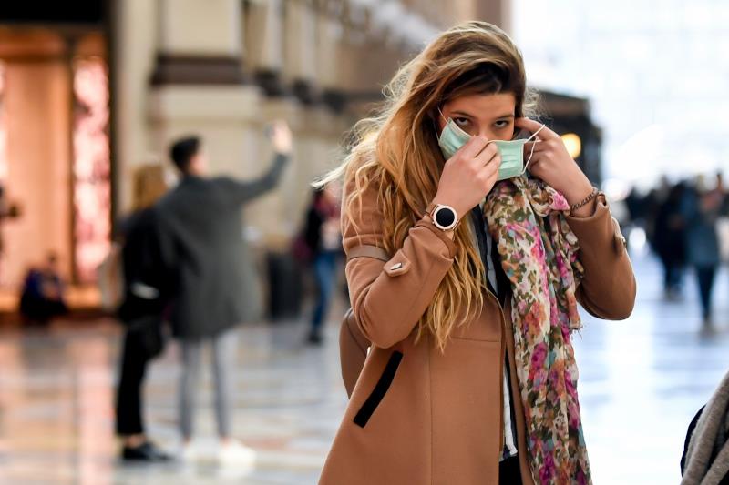 A woman wearing a sanitary mask walks through a shopping area in Milan, Italy, Monday, Feb. 24, 2020. At least 190 people in Italya€™s north have tested positive for the COVID-19 virus and four people have died, including an 84-year-old man who died overnight in Bergamo, the Lombardy regional government reported. (Claudio Furlan/Lapresse via AP)