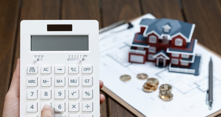 female-hand-operating-calculator-front-villa-house-model